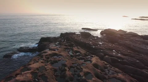 Young Active couple walking along rocks on seaside  at sunrise in Taiwan Aerial Vídeo Stock 64258901