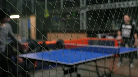 Young active friends playing table tennis. Net on foreground. Ping-pong training Stock Footage 103282295