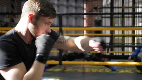 A young active male boxer practices punches in the boxing ring. Stock Footage 150266936