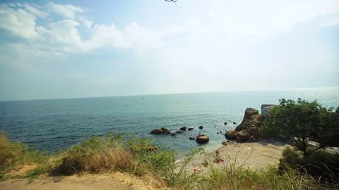 Young active muscular man looking at the sea and riding his bicycle on the stony Stock Footage 73815212