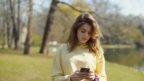 Young active woman using phone in city park. Vídeo Stock 129258484