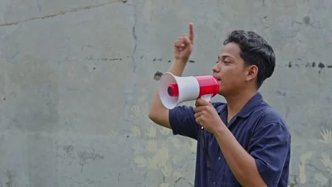 Young activist using bullhorn to lead protest gesturing with hand for press Stock Footage 335017877