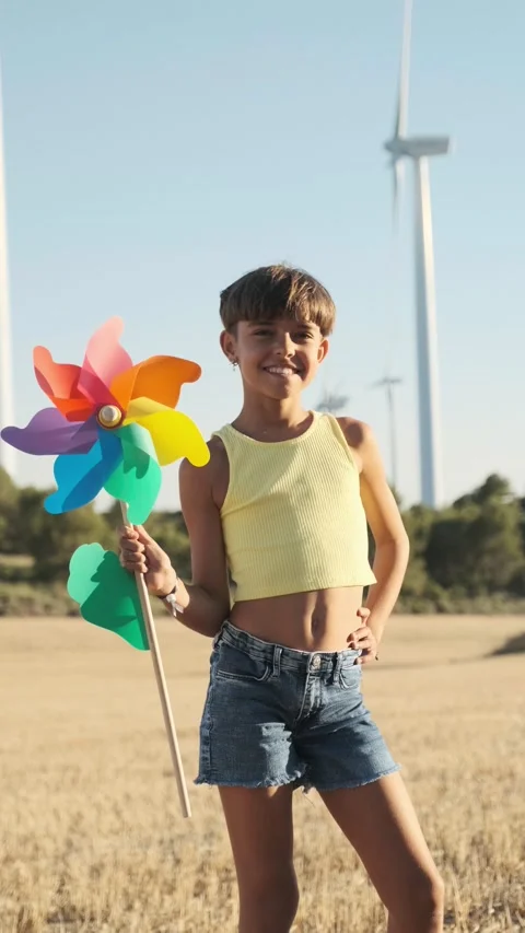 Young activist woman with a toy windmill at a wind farm - future proofing Stock Footage 201217853