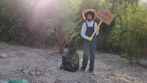 Young Activist in Work Overalls Standing with Banner Save Planet, and Looking in Stock Footage 148186897