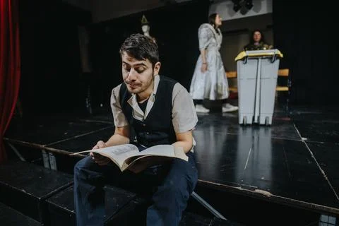 Young actor reading a script on stage during a theatre performance rehearsal Stock Photos