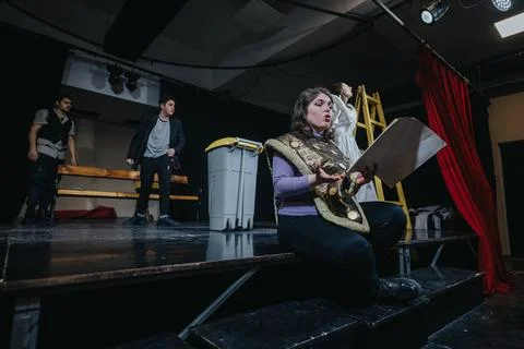 Young actors rehearse a dramatic scene onstage in a theatrical performance Stock Photos