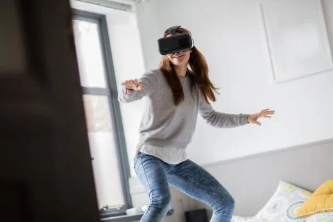 Young adult female learning to surf with VR headset Stock Photos