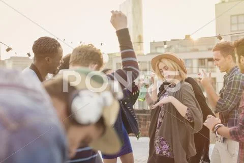 Young adult friends dancing at rooftop party Stock Photos