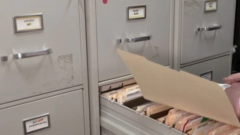 Young Adult Male Office Worker Looking Through a Folder in a File Cabinet Stock Footage