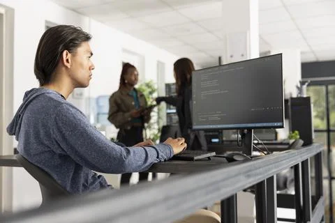 Young adult programmer coding in modern tech office Stock-Fotos