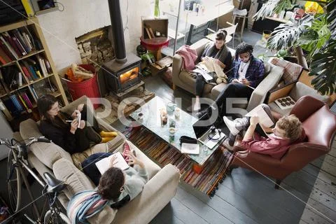 Young adult roommate friends hanging out in apartment living room Stock Photos