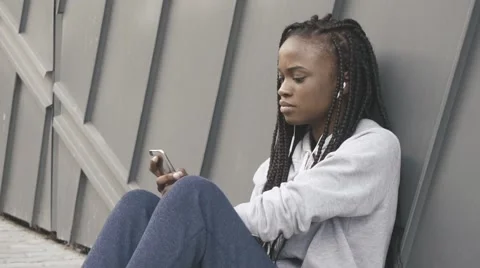 Young adult woman listening music on smartphone through earphones after training Stock Footage