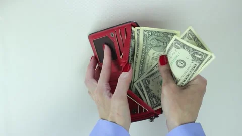 Young adult woman opens the red wallet and counts the money, then closes it Stock Footage