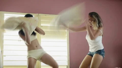 Young adult women fighting with pillows Stock Footage