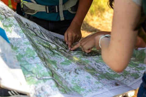 Young adults pointing at a map. Group of adults navigating using Stock Photos