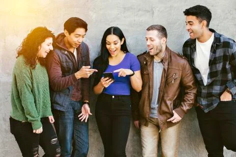 Young adults react to a smart phone in the city - Diverse - Social Media - Go Stock Photos
