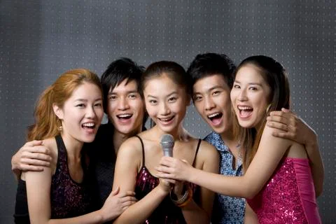 Young adults singing karaoke Stock Photos