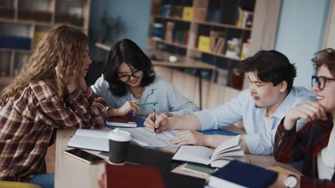Young adults study together in classroom with notebooks and pens Stock Footage 341337281