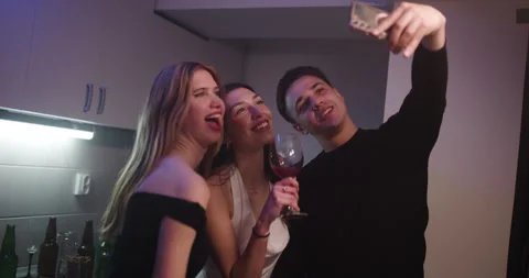 Young Adults Taking Selfies, Drinking Wine, and Celebrating at a House Party Stock Footage 314297959