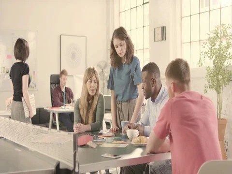 Young adults talking in startup office around a ping pong table - track left Stock Footage 72865614