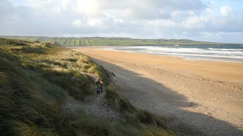Young adults walking on an empty beach. Travel Vídeo Stock 127514733