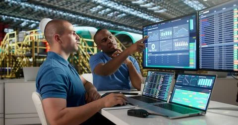 Young Aerospace Engineer Is Using SCADA Software To Check Airplane Engines. Stock Photos