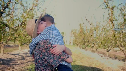 Young affectionate mother hugging her son between farm bushes at summer time Stock-Footage 108431099