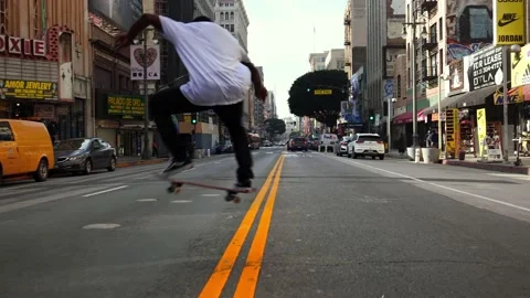 Young african american black man athlete riding skateboard on street Los Angeles Stock Footage