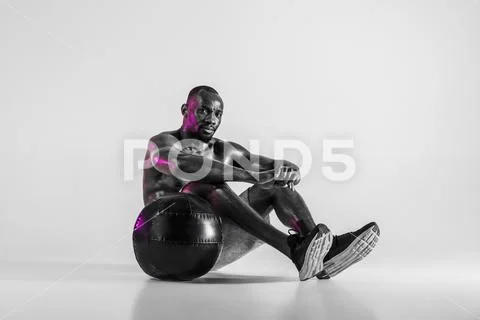 Young african-american bodybuilder training over grey background Stock Photos