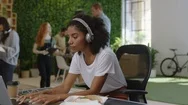 Young African American Business Woman Writing Notes Enjoying Study Listening To Stock Footage