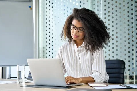 Young African American business woman using laptop computer in office. Stock Photos