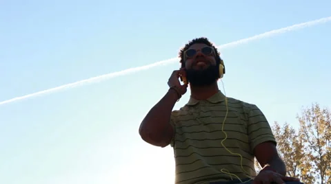 Young african american man with headphones listening to music at park Stock Footage 59555382