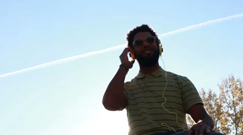 Young african american man with headphones listening to music at park Stock Footage 59555392