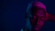 Young African American Man Moving Head On Dark Blue Background With Pink Neon Stock Footage