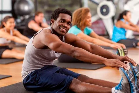 Young african-american man stretching in a gym Stock Photos