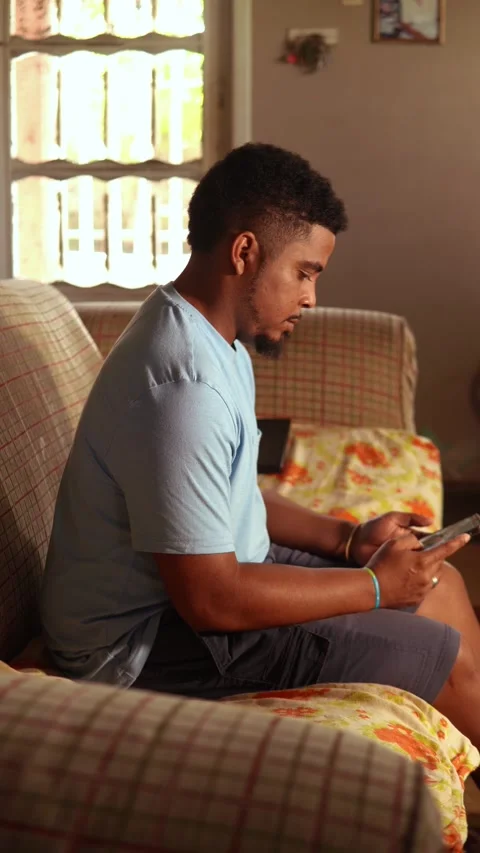 Young african american man using tablet on a sofa at home Video stock 328177968