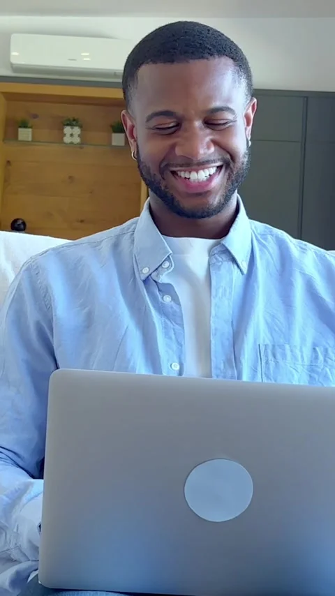 Young african american man using laptop computer while sitting comfortably Stock Footage 348249297