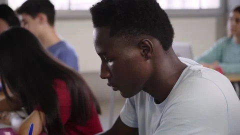 Young African American student taking test in classroom. Black boy in language Stock Footage 239472276