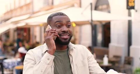 Young African American stylish man walking at city street, sipping drink and Stock Footage 148244053