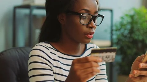 Young african american woman buying with credit card using smartphone in the Stock Footage