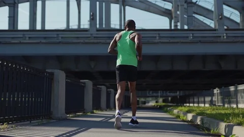 Young African athlete jogging down urban bridge Stock Footage 117065559