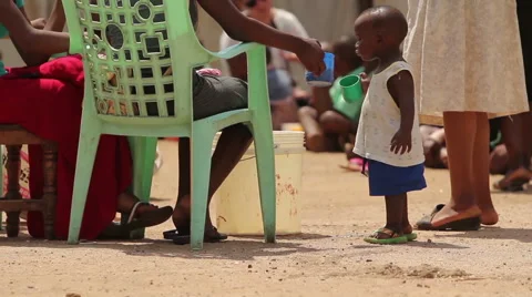 Young African child drinking from a large plastic cup Stock Footage 57947747