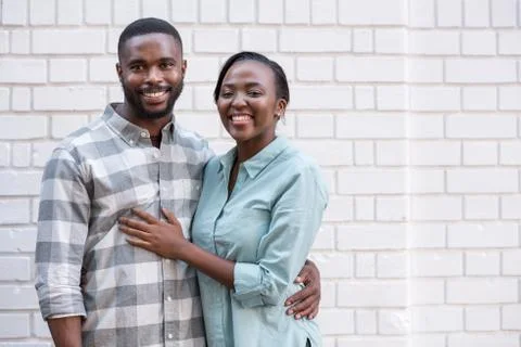 Young African couple smiling while standing together in the city Stock Photos