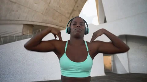 Young African fit woman listening music with headphones during workout session Stock Footage