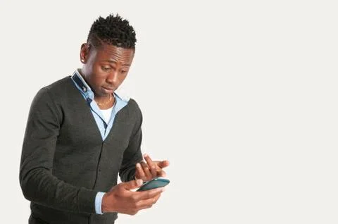 Young african guy looking at cell phone Stock Photos