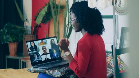 Young african lady is using a laptop for a videocall with lots of people Video stock 135786158