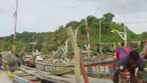 Young African Man Catching Container in Coastal Fishing Village Stock Footage 345089004