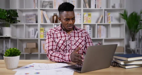 Young african man designer working on laptop computer and document. Stockbeeldmateriaal 200860686
