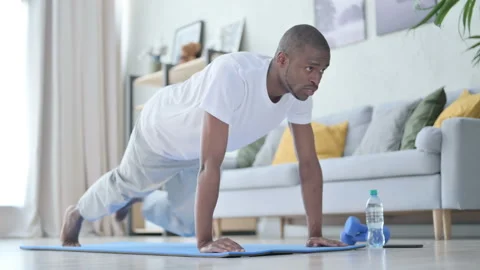 Young African Man doing Exercise on Yoga Mat at Home Stock Footage 154715889