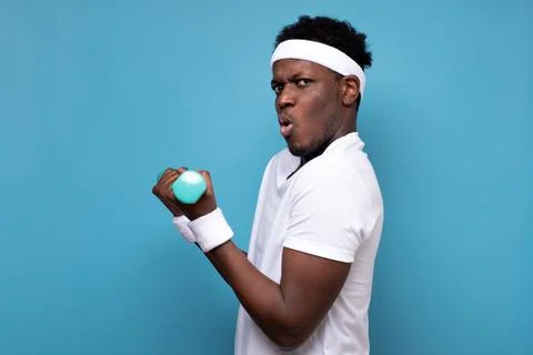 Young african man doing exercise with dumbbells spend time in gym. Stock Photos